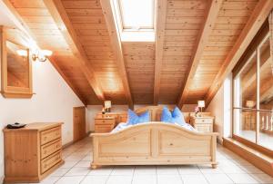 a bedroom with a large bed in a room with wooden ceilings at Ferienwohnung Ilona in Mittenwald