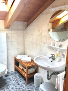 ein Bad mit einem Waschbecken und einem Spiegel in der Unterkunft Ferienwohnung Ilona in Mittenwald