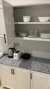 a kitchen counter with plates and a toaster on it at شقة فاخرة تحتوي على غرفتي نوم و مدخل خاص جانبي in Riyadh