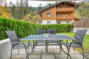 a table and chairs on a patio with a house at Haus Kemp in Zell am See