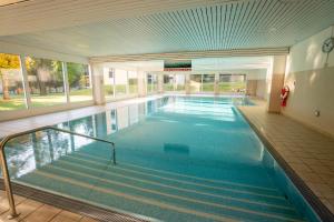 een groot zwembad in een gebouw met een zwembad bij Brentsch A23 in Scuol