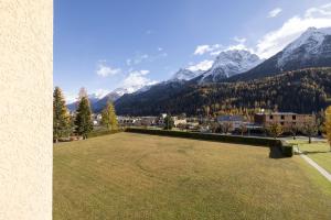 un gran campo de césped con montañas en el fondo en Brentsch A23, en Scuol