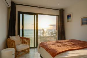 um quarto com uma cama e vista para o oceano em Le Moma by the ocean em Trois Bassins
