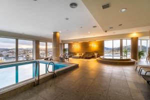 eine Hotellobby mit einem Pool mit Aussicht in der Unterkunft Holiday Inn Zilina, an IHG Hotel in Žilina