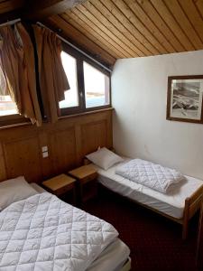 a room with two beds and two windows at Exclusive Chalet Val Thorens Center by GlobalSki in Val Thorens