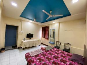 a room with two beds and a ceiling fan at MUKTAI LODGE in Solapur