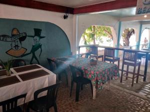 a dining room with a table and chairs and a painting at SEASCAPE in Moalboal