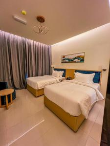 1 dormitorio con 2 camas y ventana en Season Inn Hotel_Bald Sayt en Rustāq