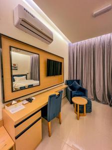 Habitación con escritorio con espejo y dormitorio. en Season Inn Hotel_Bald Sayt, en Rustāq