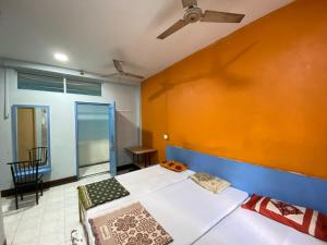 a room with two beds and a wall at MUKTAI LODGE in Solapur