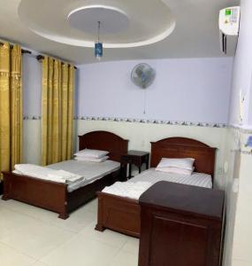 a bedroom with two beds and a table in it at Phúc Lộc Thọ Hotel in Ho Chi Minh City