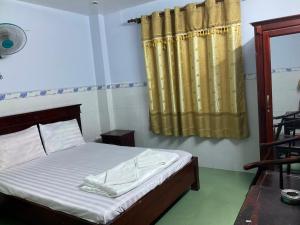 a bedroom with a bed and a yellow curtain at Phúc Lộc Thọ Hotel in Ho Chi Minh City