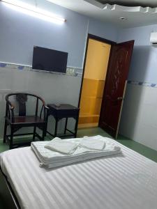 a room with a bed and two chairs and a door at Phúc Lộc Thọ Hotel in Ho Chi Minh City