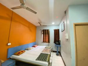 Habitación con 2 camas y ventilador de techo. en MUKTAI LODGE, en Solapur