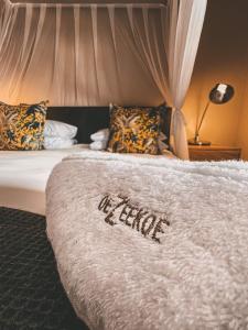 a bed with the word fragile written on it at De Zeekoe Guest Farm in Oudtshoorn