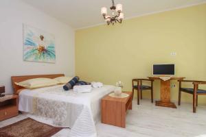 Schlafzimmer mit einem Bett, einem Schreibtisch und einem TV in der Unterkunft Apartment Jasmin in Split