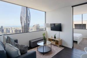 - un salon avec un canapé et une grande fenêtre dans l'établissement City Lights & Manhattan Heights - A Gem in Melbourne, à Melbourne