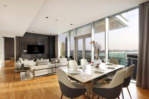 a dining room and living room with a table and chairs at Luxurious 2 BR in Bluewater w/Sea View by Livbnb in Dubai