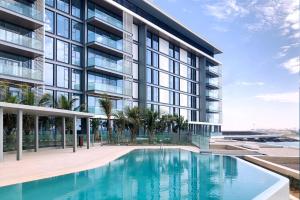 an exterior view of a building with a swimming pool at Luxurious 2 BR in Bluewater w/Sea View by Livbnb in Dubai