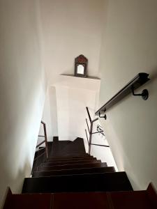 un escalier avec une horloge sur le mur dans l'établissement Villa Grazalema casa rural con encanto, à Grazalema