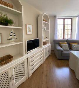 sala de estar con TV y sofá en Apartamento Plaza Grande, en Zafra