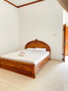 a bedroom with a wooden bed with a stuffed animal on it at Suris bungalows in Pabean Buleleng
