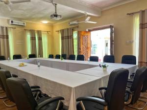 a meeting room with a large white table and chairs at Sunrise Villas in Jambiani