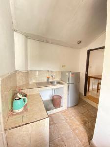 eine kleine Küche mit Spüle und Kühlschrank in der Unterkunft Suris bungalows in Buleleng