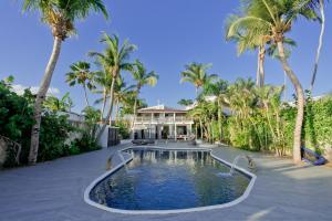 una piscina di fronte a una casa con palme di TRACADERO Beach Club & Holidays Rentals a Bayahibe