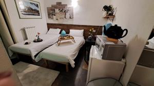 Habitación pequeña con 2 camas y TV. en Bed & Breakfast Le Due G, en Varese