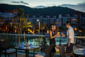 un homme et une femme debout sur un balcon dans l'établissement Angsana Lang Co, à Lang Co