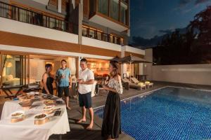 a group of people standing next to a swimming pool at Angsana Lang Co in Lang Co