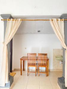 ein Esszimmer mit einem Tisch und 2 Stühlen in der Unterkunft Suris bungalows in Buleleng
