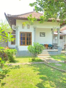 a small white house with a porch and stairs at Suris bungalows in Pabean Buleleng