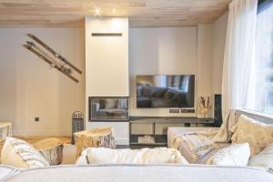 a living room with a couch and a tv at Luderna - Apartamento con jardín Marconi in Arties