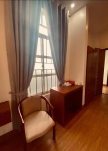 a room with a chair and a large window at Hương Sen Hotel Bac Giang in Bắc Giang
