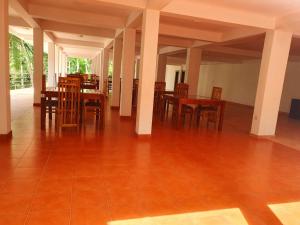 a dining room with wooden tables and chairs at Singheraja Lodge in Deniyaya