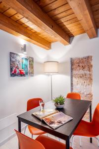 un comedor con una mesa negra y sillas naranjas en Open Sicily Homes "Residence Guascone" - Self check in, en Palermo