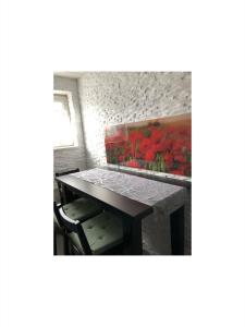 una mesa en una habitación con una pintura de flores rojas en Ferienwohnung Frank 80qm, en Bad Emstal