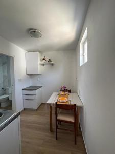 uma pequena cozinha com uma mesa e uma cadeira em Morosini Apartments em Biograd na Moru