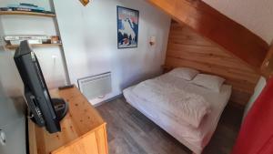 Dormitorio pequeño con cama y TV en Appartement 42M² pour 4/6 personnes à VALMEINIER 1800, en Valmeinier