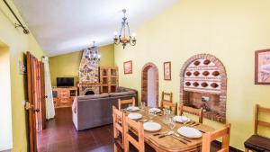 uma sala de jantar com uma mesa e uma sala de estar em Casa Herrero El Borge by Ruralidays em Almáchar
