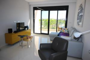 a living room with a couch and a chair at COSTA ELISA20 MIL PALMERAS in La Horadada