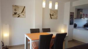 uma mesa de jantar com cadeiras e uma cozinha em PLANTA BAJA CAPRI VISTABELLA GOLF 41 em Alicante