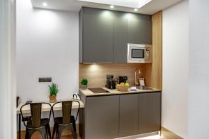 a small kitchen with a table and a microwave at numa I Goya Apartments in Madrid