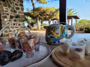een tafel met een bord eten en een vaas bij Residenza Khaddiuggia in Pantelleria