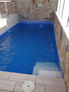 una piscina blu con un muro in pietra di Villa Sinergia 3 bedrooms a Los Alcázares