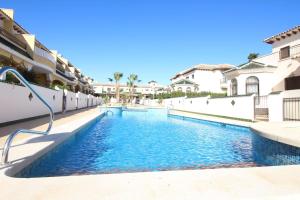 a swimming pool in a villa with blue water at Family Townhouse 6 sleeps Maribel in Ciudad Quesada