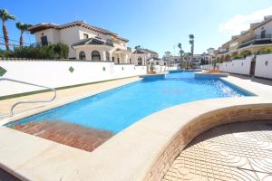 a swimming pool in front of a villa at Family Townhouse 6 sleeps Maribel in Rojales