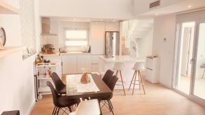 biała kuchnia ze stołem i krzesłami w obiekcie Luxury Villa Torrevieja With Swimmingpool w mieście Torrevieja